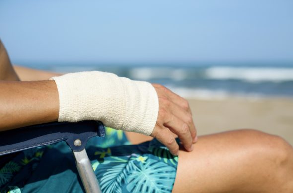 man on the beach with a bandage in his wrist